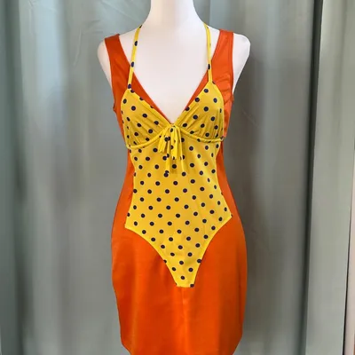 Un abito Moschino Couture audace e ironico, che gioca con i contrasti cromatici e le sovrapposizioni in un design origin