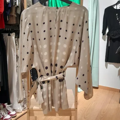 Completo composto da maglia e gonna. La maglia, così come la gonna, è beige, con pois bianchi e blu, ha una cintura che