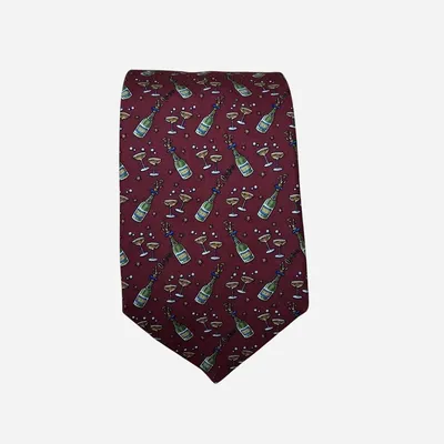 Cravatta Salvatore Ferragamo, colore bordeaux o rosso vino intenso, riprende il tema festivo con disegni di bottiglie e