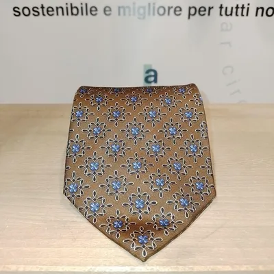 Cravatta Yves Saint Laurent su sfondo marrone con disegni ornamentali e fiori blu